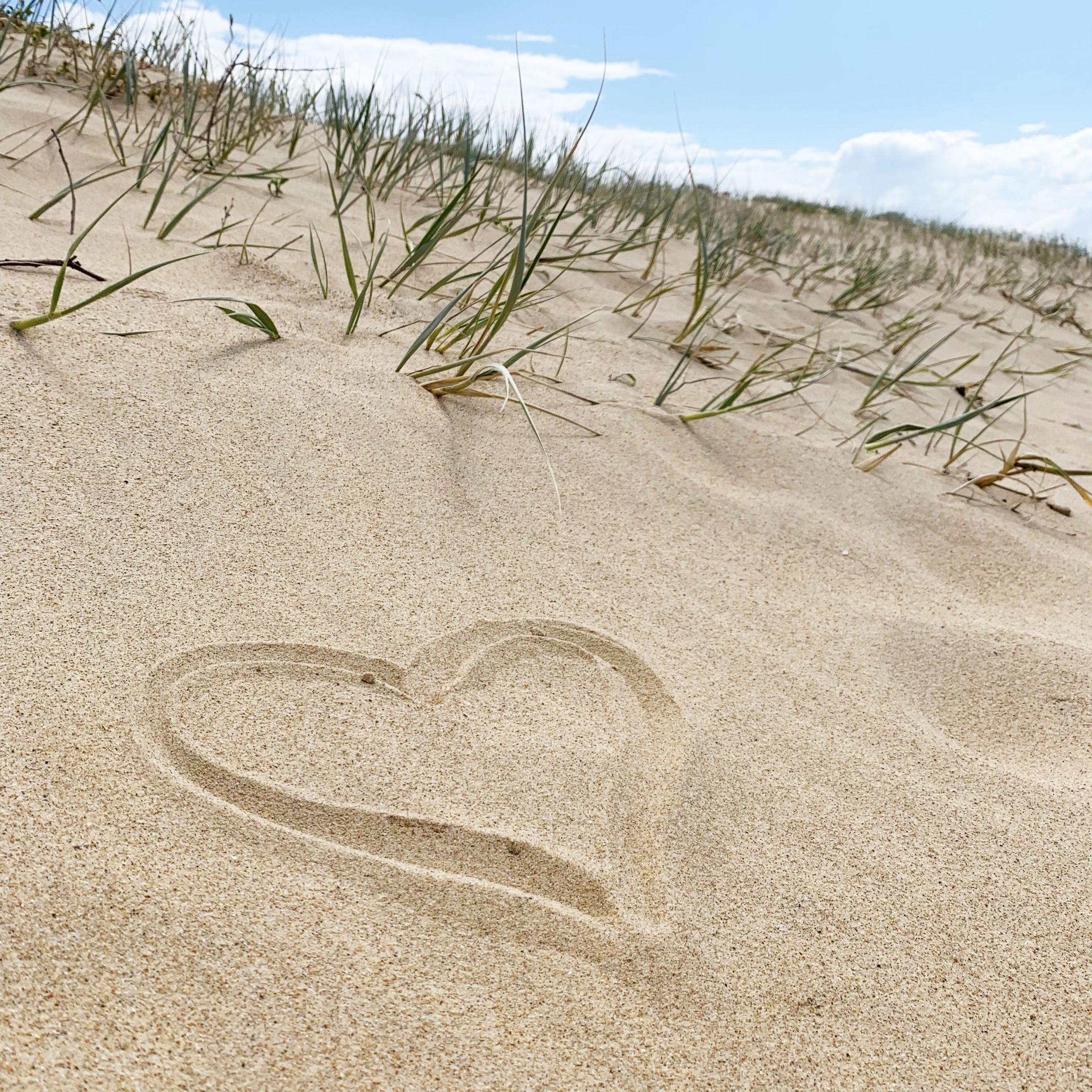 Love heart drawn in the sand at the beach